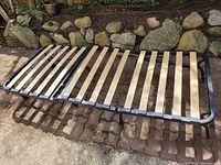 Full view of the IKEA folding futon frame showing wooden slats and metal frame.