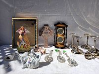 Photo of all vintage items including framed angel, figurines, wall hanging cross, clock, candle holders, and smaller pieces on white surface