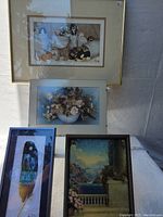 Full view of five framed artworks with varying subjects, one being a painted feather with bird image.