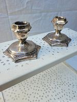 Pair of hexagonal base silver plated candlestick holders with ornamental faceted stems.