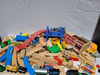 Full lot showing wooden tracks, trains, and accessories spread on display against a white backdrop