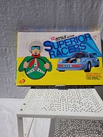 Box front showing Superior Racers branding and 12 models of pull back action cars.