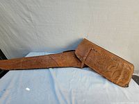 Full view of the vintage leather case showing the elongated rectangular shape and embossed jungle-themed design