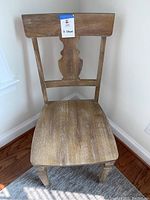 Front view of single wooden chair showing seat and decorative backrest