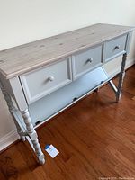 Front view of the console table showing the 3 drawers and natural wood finish top