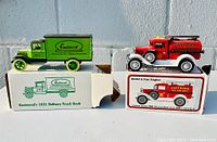 Image showing both the green Eastwood 1931 delivery truck bank and red Ford Model A Fire Engine toy trucks along with their boxes.