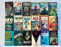 Top view of 20 vintage paperback books arranged in three rows. Titles include Conan series, UFO Experience, Star Trek, horror and thriller themes.