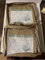 Photo of two packaged large patio armless chair covers labeled 'Premium Cover'.