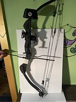 Side view of black Browning compound bow with a rigid riser and cams on limbs.