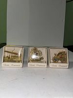 Three brass ornaments each in individual white boxes labeled 'Classic Ornaments'.