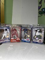 Front view of four McFarlane sports figures still in original packaging showing players Carlos Delgado, Robert Lang, Nomar Garciaparra, and Carlos Beltran.