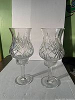 Pair of Royal Limited crystal hurricane candle holders with intricate cut patterns standing upright on a white background.