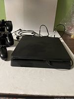 Sony PS4 Slim console with cables on flat surface