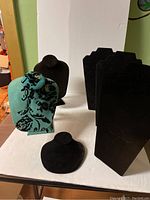 Image showing all six displays together on table including turquoise and black velvet busts and tall flat black stands