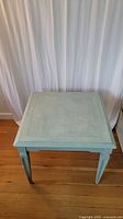 Top view of the wooden square end table painted chalk blue showing surface and edges.