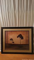 Full view of framed print showing tree landscape with glass and wood frame.