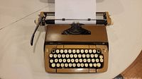 Front view of Smith Corona Galaxie Twelve XII typewriter with paper inserted, showing keyboard and carriage lever.