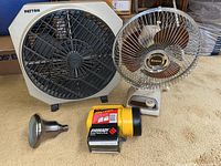 Photo showing all items including Patton box fan, Emerson tabletop fan, Eveready flashlight, and brass shower head on carpeted floor.