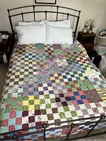 View of the full patchwork quilt cover on a queen bed displaying multiple colorful squares and patterns.