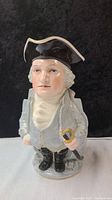 Front view of the Toby mug depicting George Washington with detailed facial features, blue-gray coat, and trisected black hat.