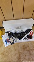 RC Stealth Stingray Bomber airplane in original white box with foam inserts, remote control, DVDs and instruction papers displayed on carpet.
