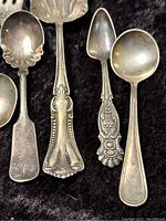 Close-up of different spoon handles showing ornate and classic patterns