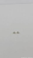 Pair of natural light champagne colored Zircon oval cut gemstones approx 6x4mm, shown on plain background.