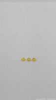 Photo of three natural canary yellow sapphires arranged in a row on white background, showing size and color consistency