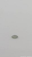 Front view of a marquis cut olive green sapphire gemstone on a white background.