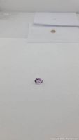 Single pear-shaped purple amethyst gemstone placed on a white background, showing size and shape.