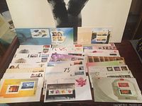 Photo showing a spread of multiple colorful envelopes with unique stamps arranged on a table.