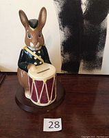 Front view of the Royal Doulton bunny bank sitting with a drum, showing facial details and coin slot on the drum.