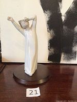 Full view of the white porcelain figurine of boy yawning and stretching on a round base