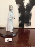 Full view of Lladro figurine girl with candle on wooden base