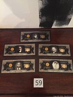 Five USA $2 notes with black and gold design, each showing a different Pawn Stars family member and the number '2' in gold leaf.
