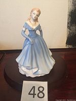 Front view of Royal Doulton figurine in blue and white gown with gold bead necklace