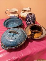 Overall view of all 8 handmade ceramic pieces showing various items including bowls, jugs, gravy boat and vase.