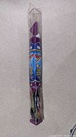 Purple packaged dragon kite in clear plastic, showing branding and length