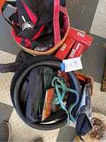 Photo showing a mix of dog accessories including tote bags, dog seat cover, leashes, tie-out cords in baskets and boxes.