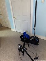 Everlast freestanding punching bag cover and base shown with Cycleops bike trainer frame lying on floor