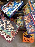 Photo showing Sorry, Balderdash, Up Words games among other assorted board games in box