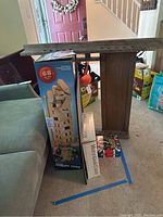 Photo showing jumbling tower game and wooden multi-game chest together in living room.