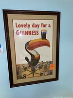Full view of the Guinness toucan wall art in its frame showing overall condition and size with a slight glare on the glass.