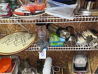 Wide shelving view showing various kitchen items including pizza stone on wicker tray, thermos, and silverware set with labeled price tag