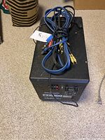 Polk Audio PSW100 powered subwoofer with audio cables coiled on top