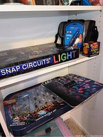 Shelf display showing Star Wars Fighter Pods Super Battle Set, Snap Circuits Light box, Misty Mate personal humidifier with carrying case, and Flaming Pumpkin Lite box