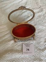 Open view of the antique brass jewelry box showing the red velvet interior and the glass lid