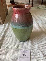 Front and side view of the ceramic vase highlighting the red, blue, and green glaze.