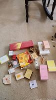 Overview photo showing all perfume boxes and bottles spread on carpet around a table leg.
