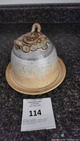 Side view of the pottery butter dish with textured lid handle and base plate.